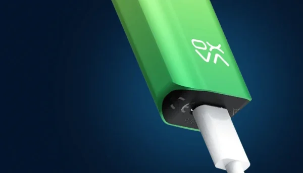 OXVA Xlim pod kit in green charging over USB-C