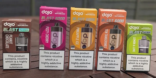 Vaporesso Dojo Blast 6000 pod packs in five flavours including Fizzy Cherry, Pineapple Ice and Ten Tangerines on a wooden surface