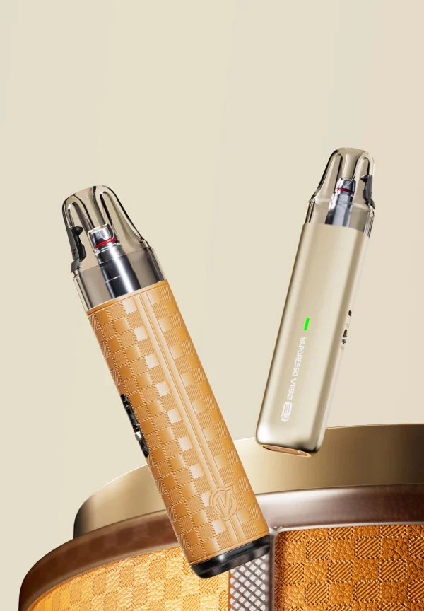 Vaporesso Vibe SE 2 in Leather Brown and Gleaming Gold finishes leaning against a rattan bowl on a warm beige background