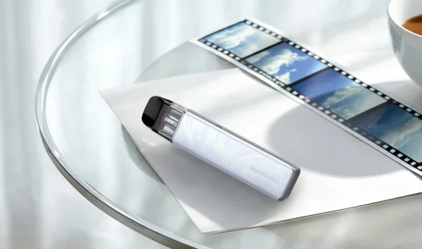 Vaporesso XROS 6 Mini pod kit in Plume White resting on a glass table