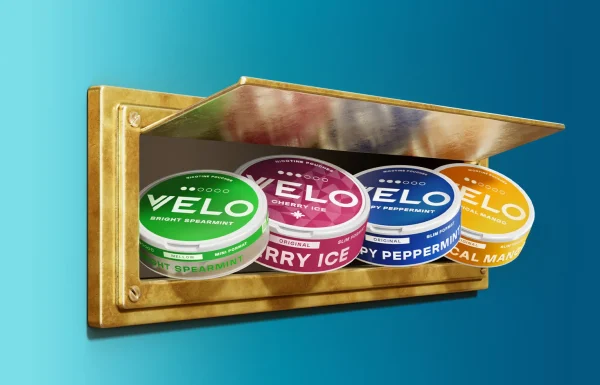 Velo nicotine pouch range in a gold letterbox including Crispy Peppermint blue tin on teal background