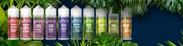 All ten Wild Roots shortfill bottles arranged in a row against a dark navy background with tropical leaves - Pomegranate, Jewel Raspberry, Autumn Grape, Mint Tea and more